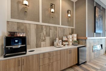A modern kitchen with wooden cabinets and a stone backsplash.